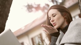 A photo of a beautiful woman blowing a kiss to whom she is on a video call with